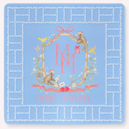 The Bamboo Blossom Christmas Edition Mahjong Mat featuring a festive bamboo lattice border design, monkeys with Christmas hats, ornaments, bows, birds, flowers and leaves with the Merry Mahjong Logo.