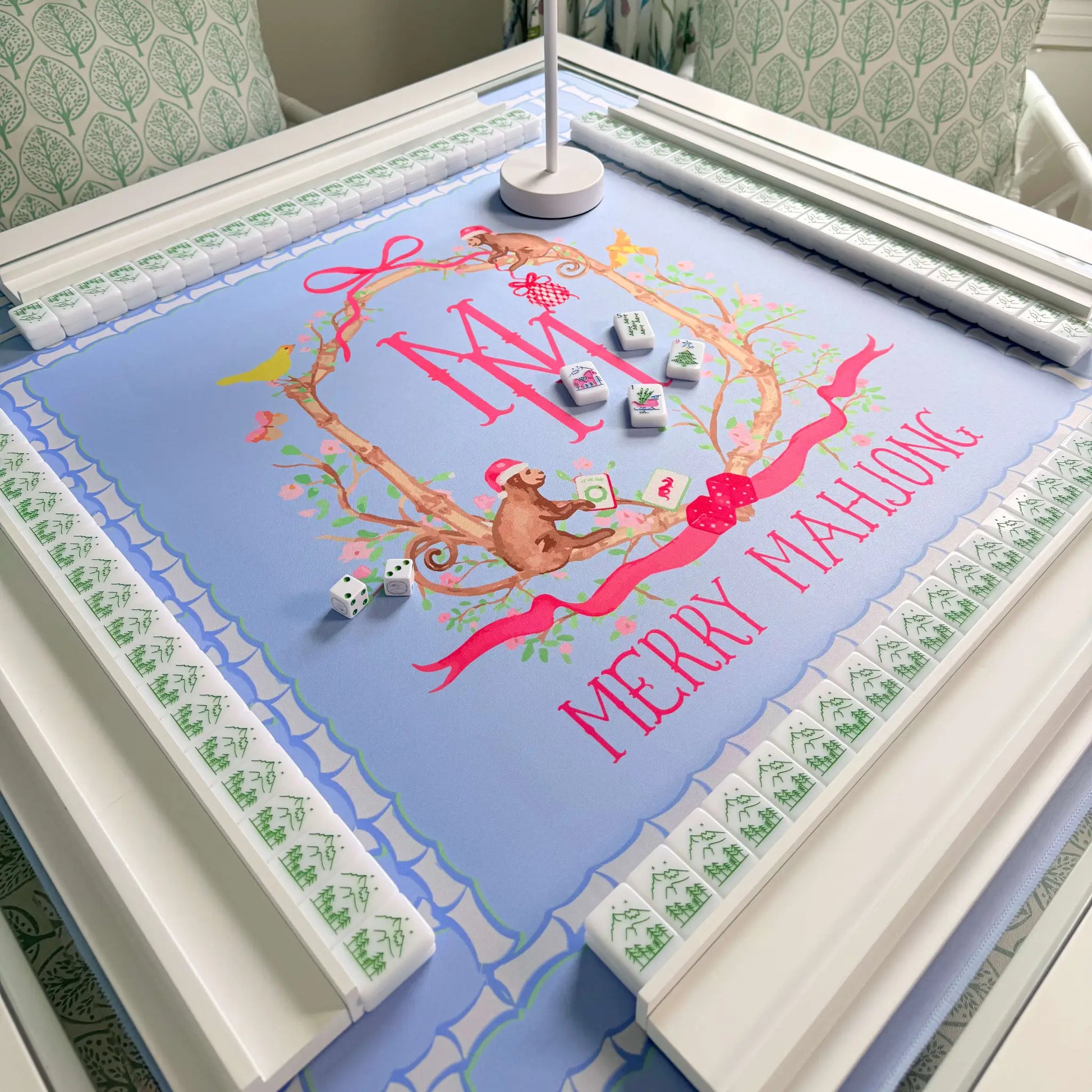 The Bamboo Blossom Christmas mahjong mat displayed with white wooden racks and a Christmas mahjong tile set.