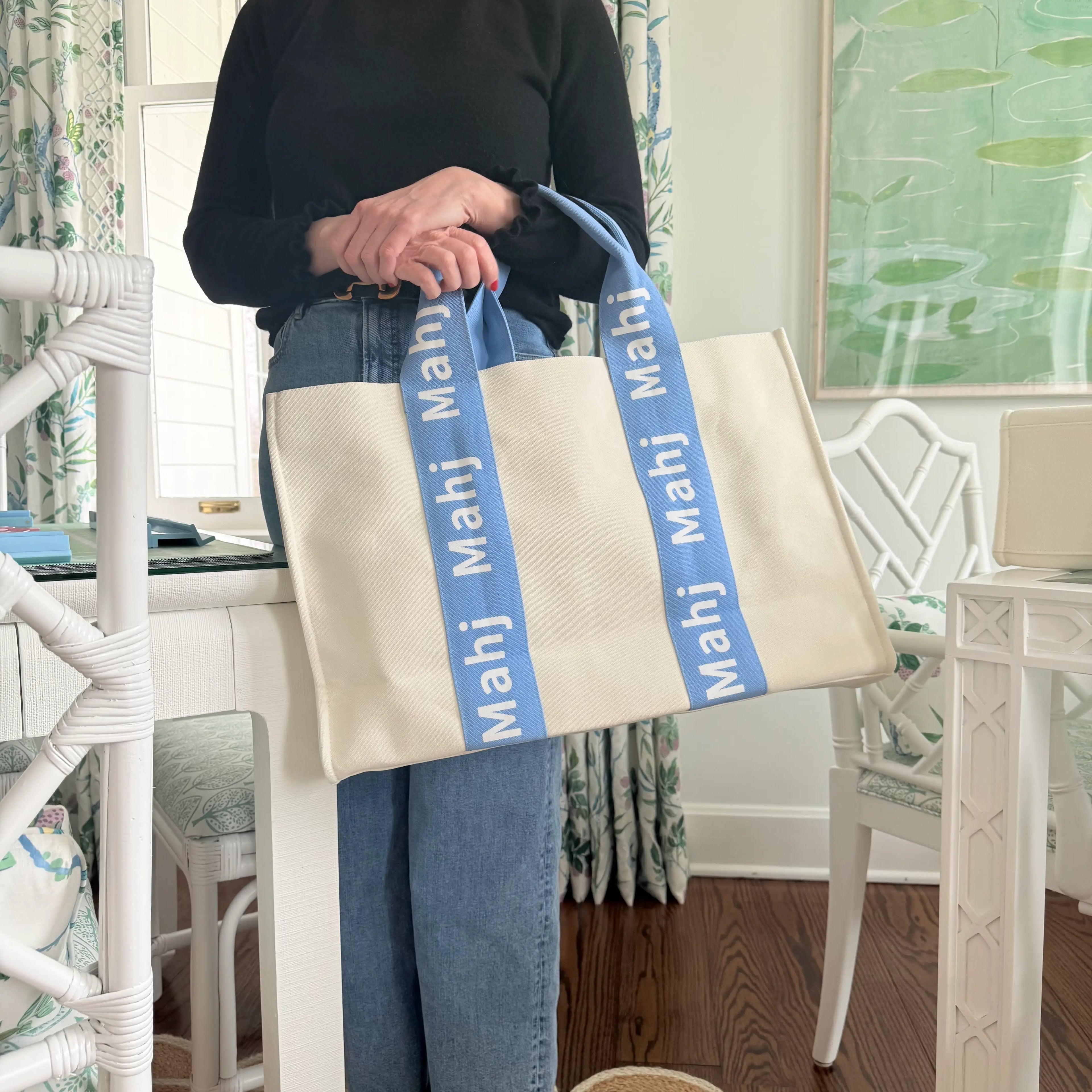 Light blue oversized Mahjong tote bag being carried by its handles.