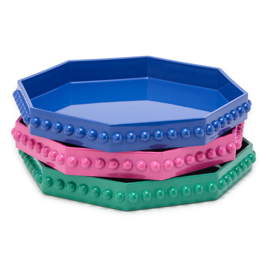 Stacked octagonal lacquered trays in pink, blue, and green with hobnail edge