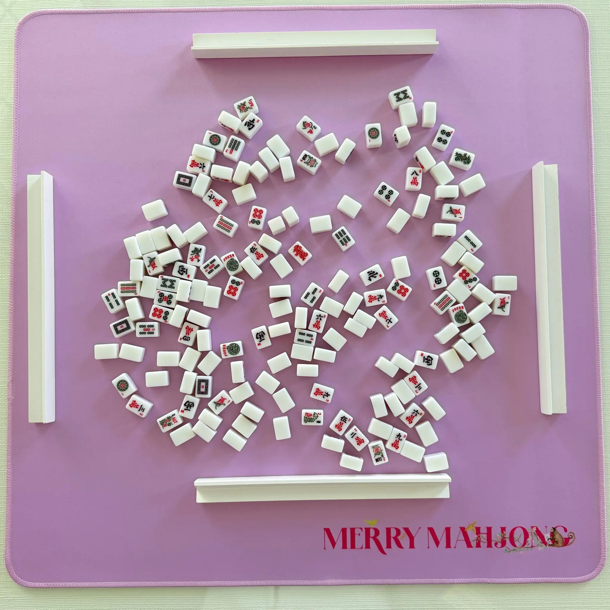 Purple mini travel Mahjong mat with miniature tiles and white racks set up for play.