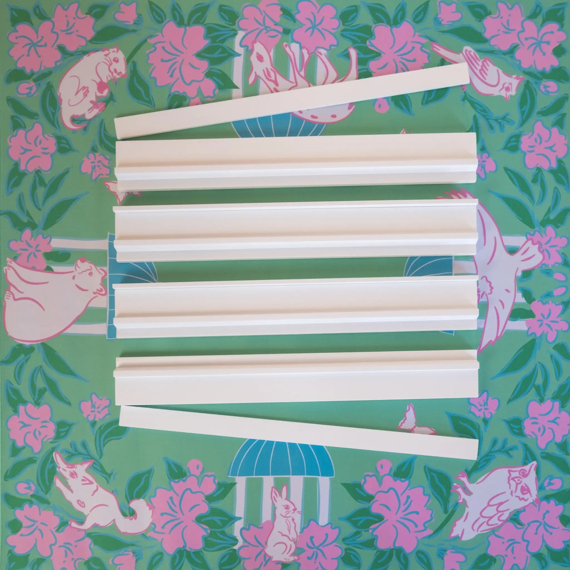 White wooden mahjong racks with magnetic pushers on top of the southern springs mahjong mat.